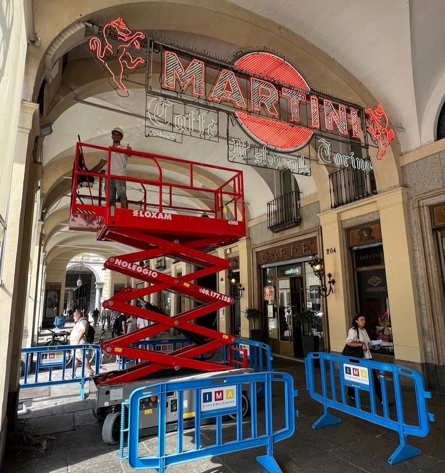 Operai al lavoro per pulire le storiche insegne del Caffè Torino